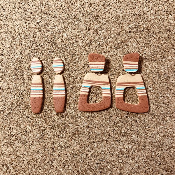 Two pairs of earrings in different shapes with desert colors.